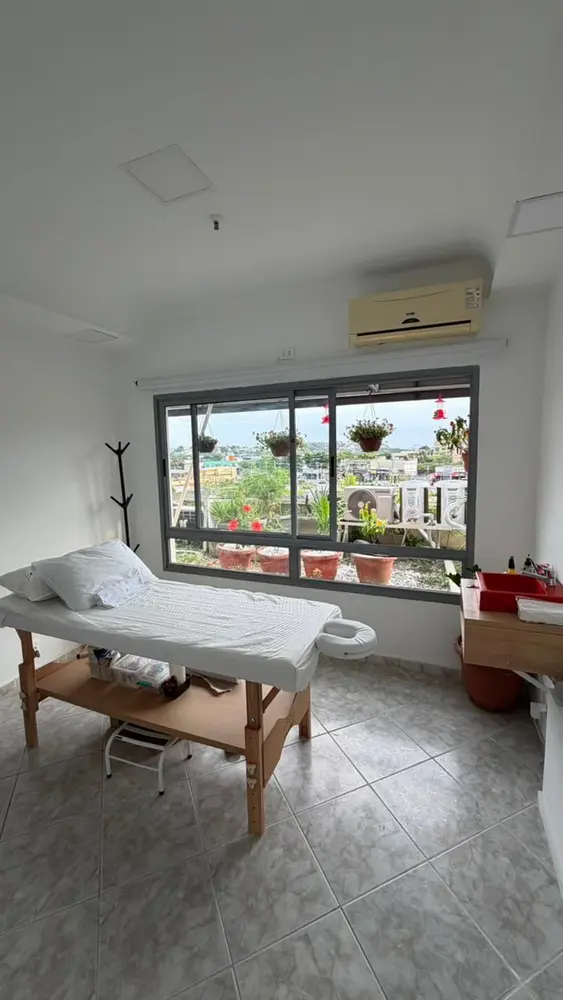 Sala de estética com maca e janela ampla